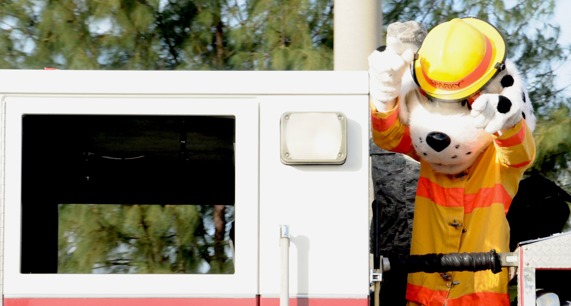 ANDERSEN AIR FORCE BASE, Guam— Sparky the Fire Dog waves at members of the Andersen community as the Fire Prevention Week parade travels through base housing here, Oct. 8. Families came out to see the parade that the Fire and Emergency Response flight held to kick off Fire Prevention Week. (U.S. Air Force photo by Senior Airman Benjamin Wiseman/Released)