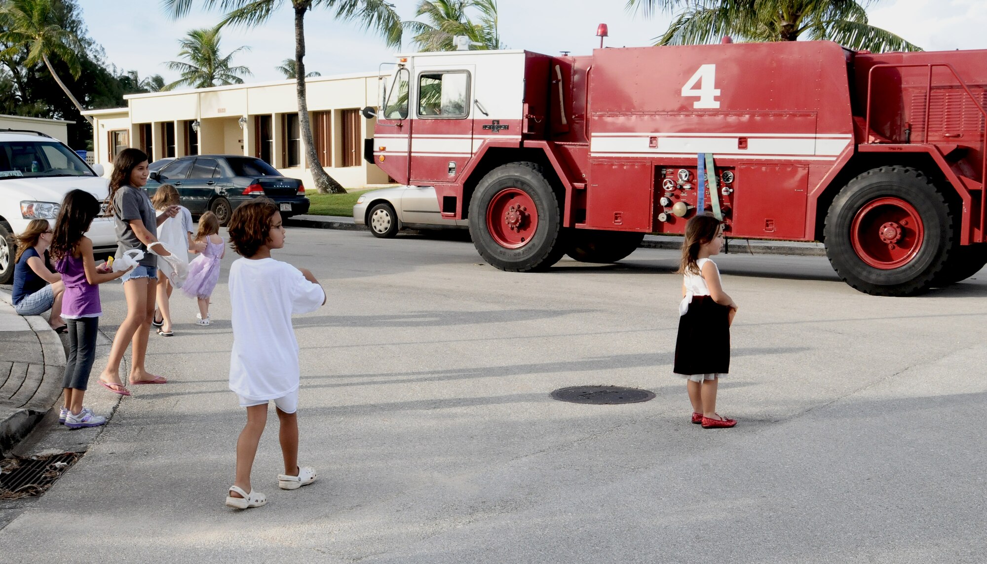 ANDERSEN AIR FORCE BASE, Guam—Children from the Andersen community scurry for candy as the Fire Prevention Week parade travels though base housing here, Oct. 8.  Several emergency response vehicles were featured in the parade, and candy was tossed to waiting children as the parade traveled through the community. (U.S. Air Force photo by Senior Airman Benjamin Wiseman/Released)