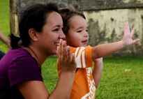 ANDERSEN AIR FORCE BASE, Guam—Michelle Wood and her son, Kai, Andersen dependents, wave as the Fire Prevention Week parade travels though base housing here, Oct. 8. Andersen’s theme this year for Fire Prevention week is “Protect Your Family from Fire,” and the Andersen Fire and Emergency flight will be having events from Oct. 9-15 to educate base personnel on fire safety. (U.S. Air Force photo by Senior Airman Benjamin Wiseman/Released)