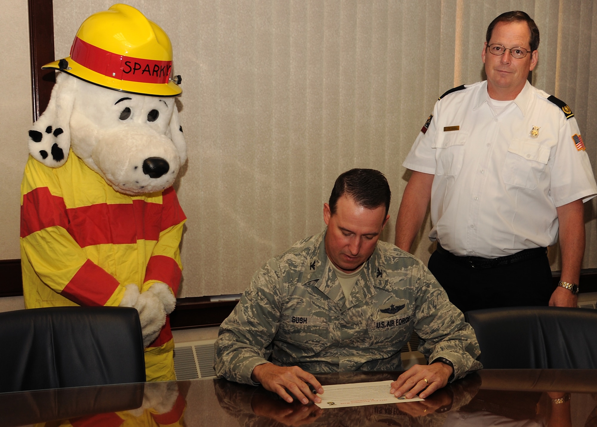 Col. Tim Bush, 319th Air Base Wing commander, reads the Fire Prevention Week Proclamation on Oct. 11 at Grand Forks Air Force Base, N.D.  Col. Bush – along with Ron Berg, 319th Civil Engineering Squadron fire chief Sparky the Fire Dog – signed the proclamation to commit to the safety and security of all those living, working and visiting the base.  This year’s theme is “Protect Your Family from Fire” to help lower the annual average of approximately 3,000 lost lives due to fire incidents. (U.S. Air Force photo by Airman 1st Class Ashley N. Taylor)