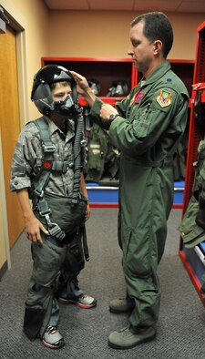 U.S. Air Force Lt. Col. Christopher Sage, 389th Fighter Squadron commander, explains to Carson McIe the importance of each part of the flight suit, Oct. 4, 2011, at Mountain Home Air Force Base, Idaho. McIe and his parents came to Idaho to meet the troops they supported for six months while they were deployed to Afghanistan. (U.S. Air Force photo by Airman 1st Class Heather Hayward/Released) 

