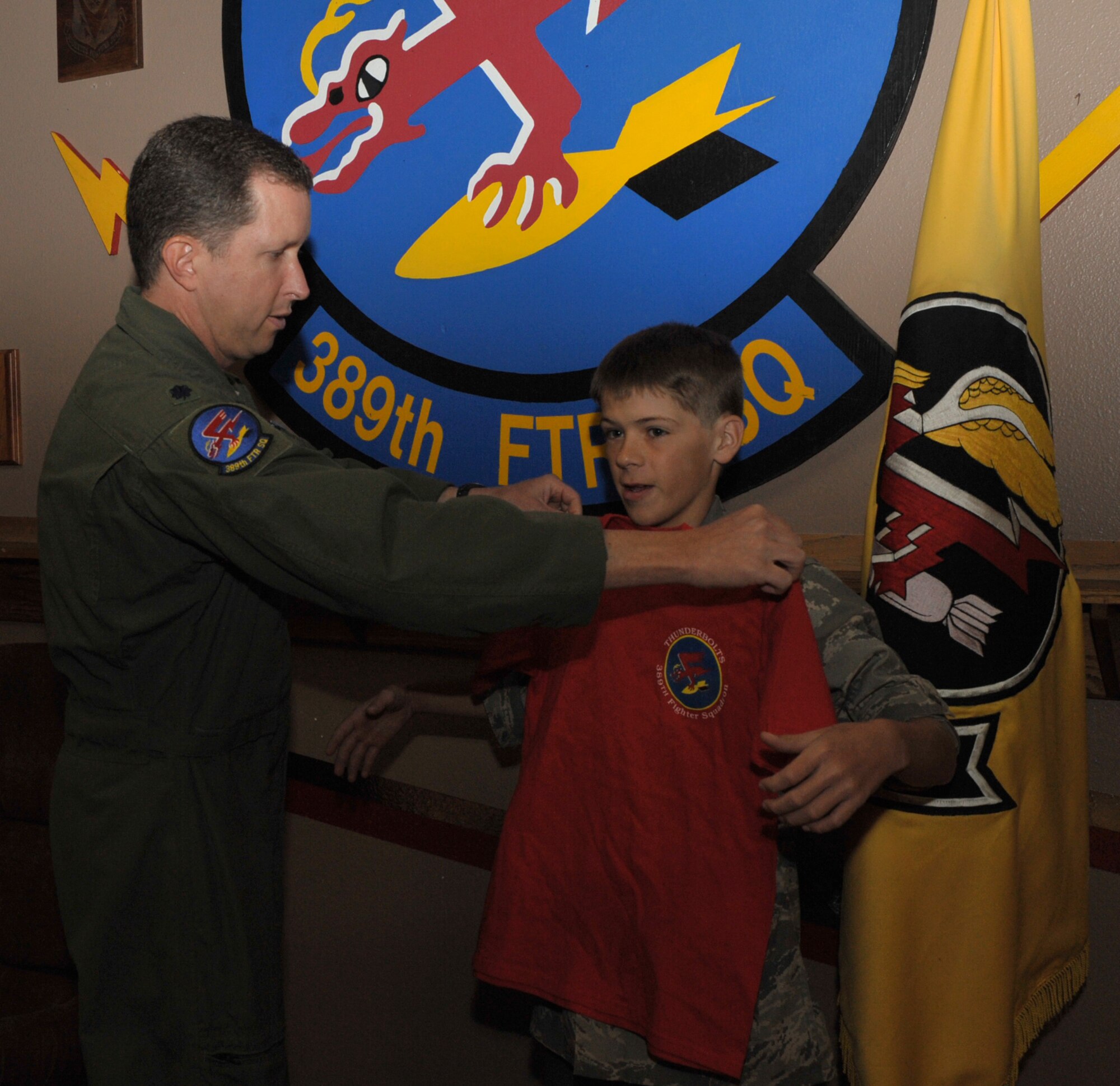 Lt. Col. Christopher Sage, 389th Fighter Squadron commander, presents a squadron t-shirt to Carson McIe, Oct. 4, 2011, at Mountain Home Air Force Base, Idaho. McIe raised more than $1000 to send care packages to the troops. (U.S. Air Force photo by Airman 1st Class Heather Hayward)