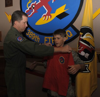 U.S. Air Force Lt. Col. Christopher Sage, 389th Fighter Squadron commander, presents a squadron t-shirt to Carson McIe, Oct. 4, 2011, at Mountain Home Air Force Base, Idaho. McIe raised more than $1000 to send care packages to the troops. (U.S. Air Force photo by Airman 1st Class Heather Hayward/Released) 


