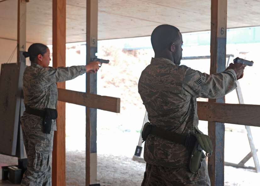 Senior Airman Chelsea Browning, 7th Bomb Wing, and Senior Airman Derrick Monroe, 7th Logistics Readiness Squadron, fire down range for M-9 qualification, Oct. 5, 2011, at Dyess Air Force Base, Texas. Airmen must go through M-9 qualification before they can deploy. (U.S. Air Force photo by Airman 1st Class Cierra Bullock/Released)