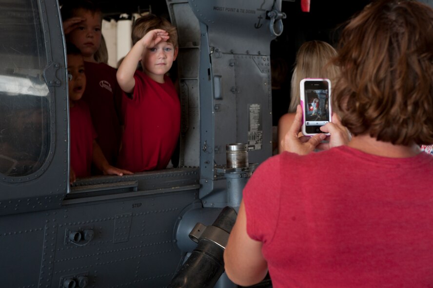 Anissa, wife of U.S. Air Force Tech. Sgt. Duane Hayes from the 38th Rescue Squadron, takes a photo of her son, Landon during the HH-60G Pave Hawk tour portion of Spouse Orientation Day Oct. 7, 2011, at Moody Air Force Base, Ga. The aircraft tour allowed family members to interact with equipment their military member works with on a daily basis. Spouse Orientation Day is an annual event that shows the squadron support of its deployed members’ families. (U.S. Air Force photo by Staff Sgt. Joshua J. Garcia/Released)  