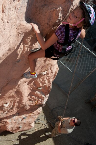 Lexi, daughter of U.S. Air Force Tech. Sgt. Eric Kelley, 38th Rescue Squadron, reaches the top of a rock wall during the squadron's Spouse Orientation Day Oct. 7, 2011, at Moody Air Force Base, Ga. The rock wall is one of the few unique features 38th RQS members use to train and maintain physical training standards. Allowing family members to experience this firsthand highlights the unusual physical training the 38th RQS members go through to ensure their combat readiness. (U.S. Air Force photo by Staff Sgt. Joshua J. Garcia/Released)