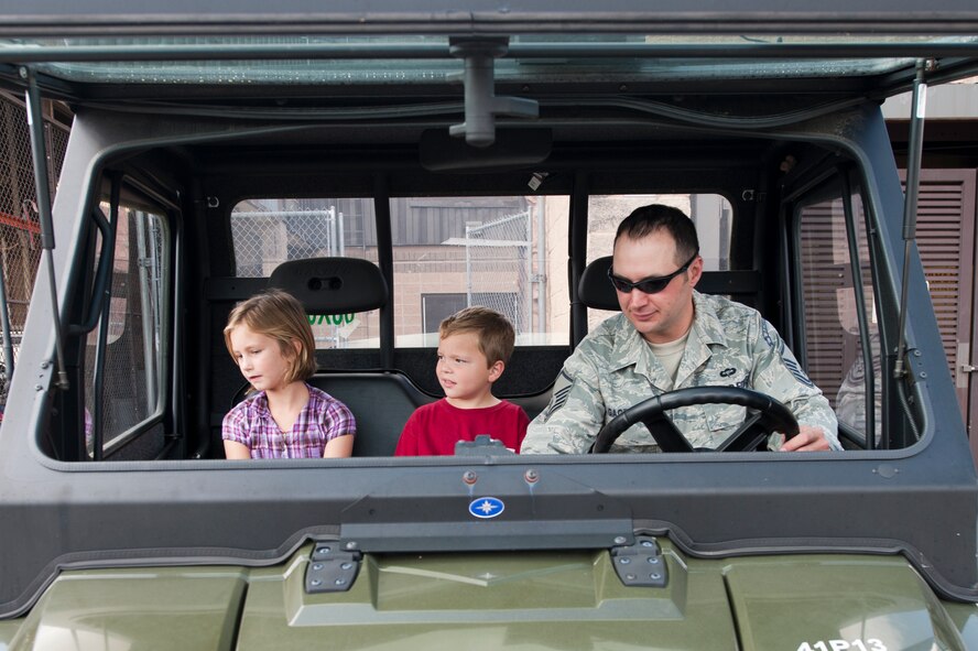 U.S. Air Force Master Sgt. Philip Gacek, 38th Rescue Squadron, takes kids for a ride in an all terrain vehicle during Spouse Orientation Day at Moody Air Force Base, Ga., Oct. 7, 2011. The ride allowed children of the 38th RQS members to see some of the utility vehicles that are used by their parents on a daily basis. (U.S. Air Force photo by Staff Sgt. Joshua J. Garcia/Released) 