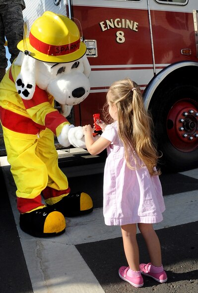 Eva, 2, daughter of Peggy and Staff Sgt. Jesse Marshall, 2nd Civil Engineer Squadron firefighter, receives candy from Sparky, the fire prevention mascot, on Barksdale Air Force Base, La., Oct. 9. Sparky, along with several Airmen from the Barksdale Fire Department, rode through base housing to bring awareness to the beginning of Fire Prevention week. (U.S. Air Force photo/Senior Airman Amber Ashcraft)(RELEASED)