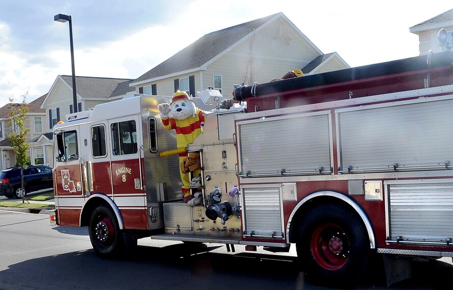 Sparky, the fire prevention mascot, waves to children as he rides through base housing on Barksdale Air Force Base, La., Oct. 9. Sparky, along with several Airmen from the Barksdale Fire Department, rode through base housing to bring awareness to the beginning of Fire Prevention week. (U.S. Air Force photo/Senior Airman Amber Ashcraft)(RELEASED)