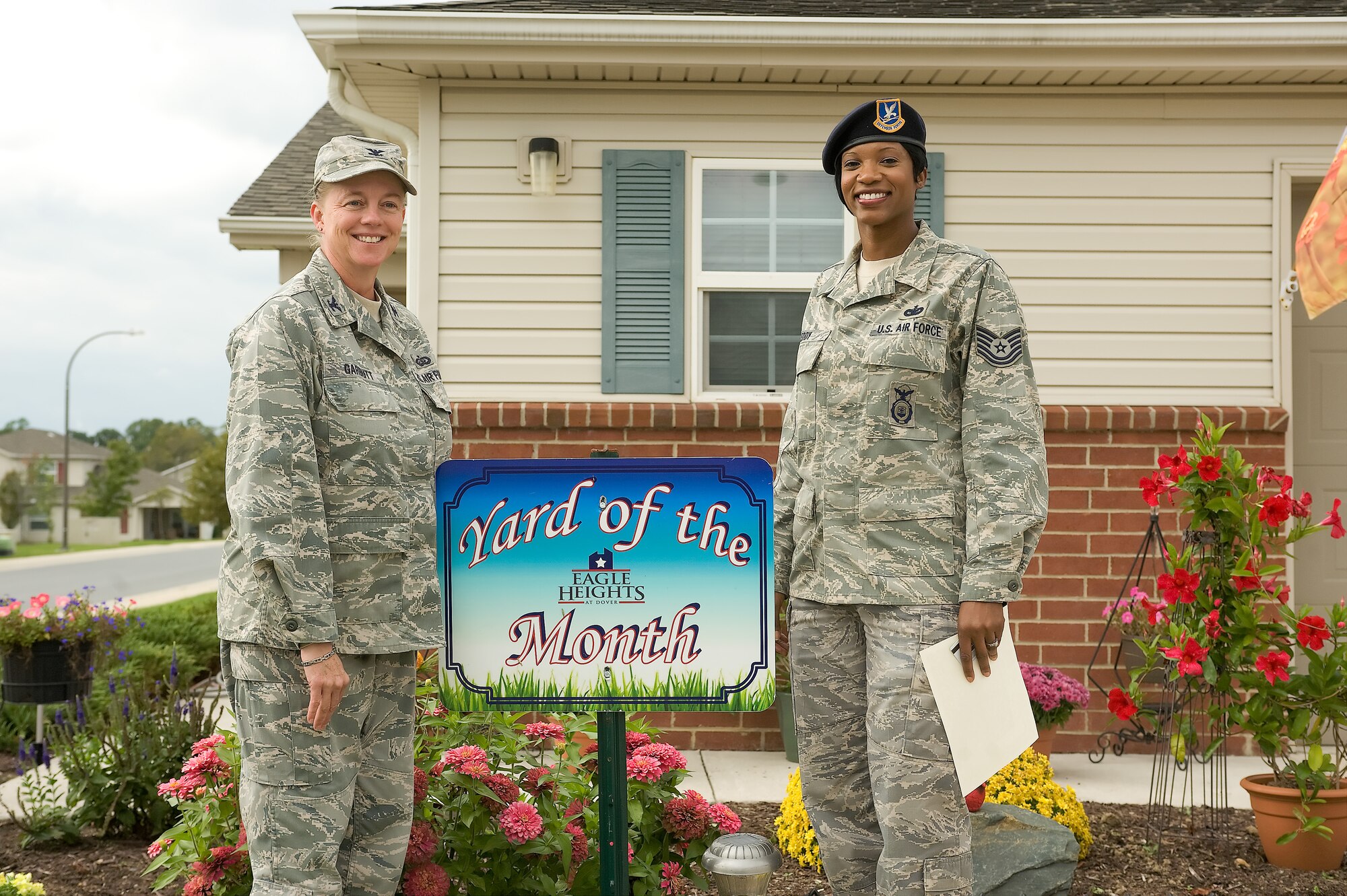 Col. Joan Garbutt (left), commander of the 436th Mission Support Group, stands with Tech. Sgt. Letisia Eddy, recognizing Eddy as the Orioles Cove Yard of the Month winner for September at Dover Air Force Base, Del. (U.S. Air Force photo by Steve Kotecki)