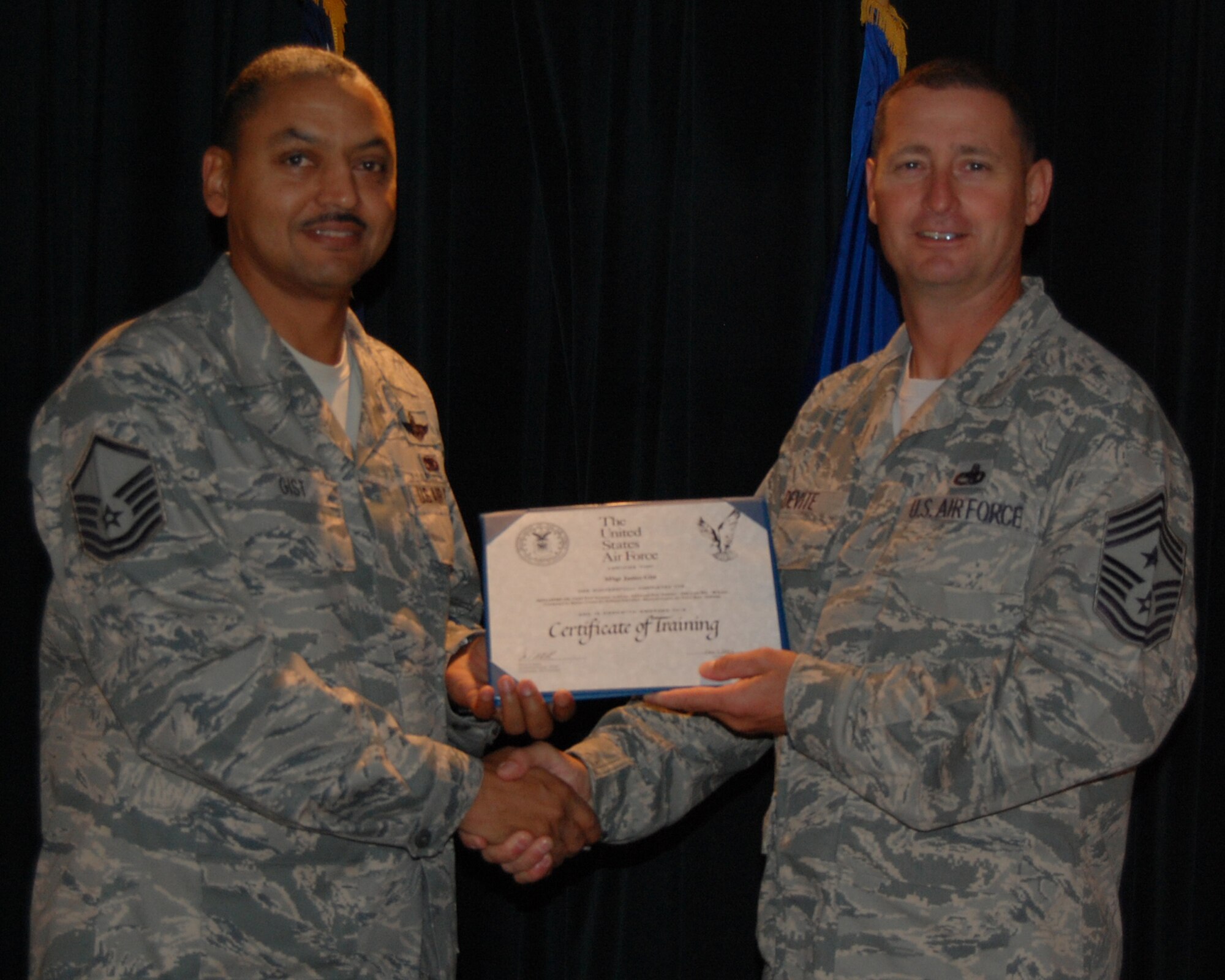 LAUGHLIN AIR FORCE BASE, Texas - Chief Master Sgt. Ray DeVite, 47th Flying Training Wing command chief, congratulates and presents a certificate for the First Sergeants Seminar Class 12A to class leader Master Sgt. James Gist, 514th Air Mobility Operations Squadron flight engineer.  NCOs from across the country attended the week-long seminar hosted here. (U.S. Air Force photo/Master Sgt. Peter Borys)