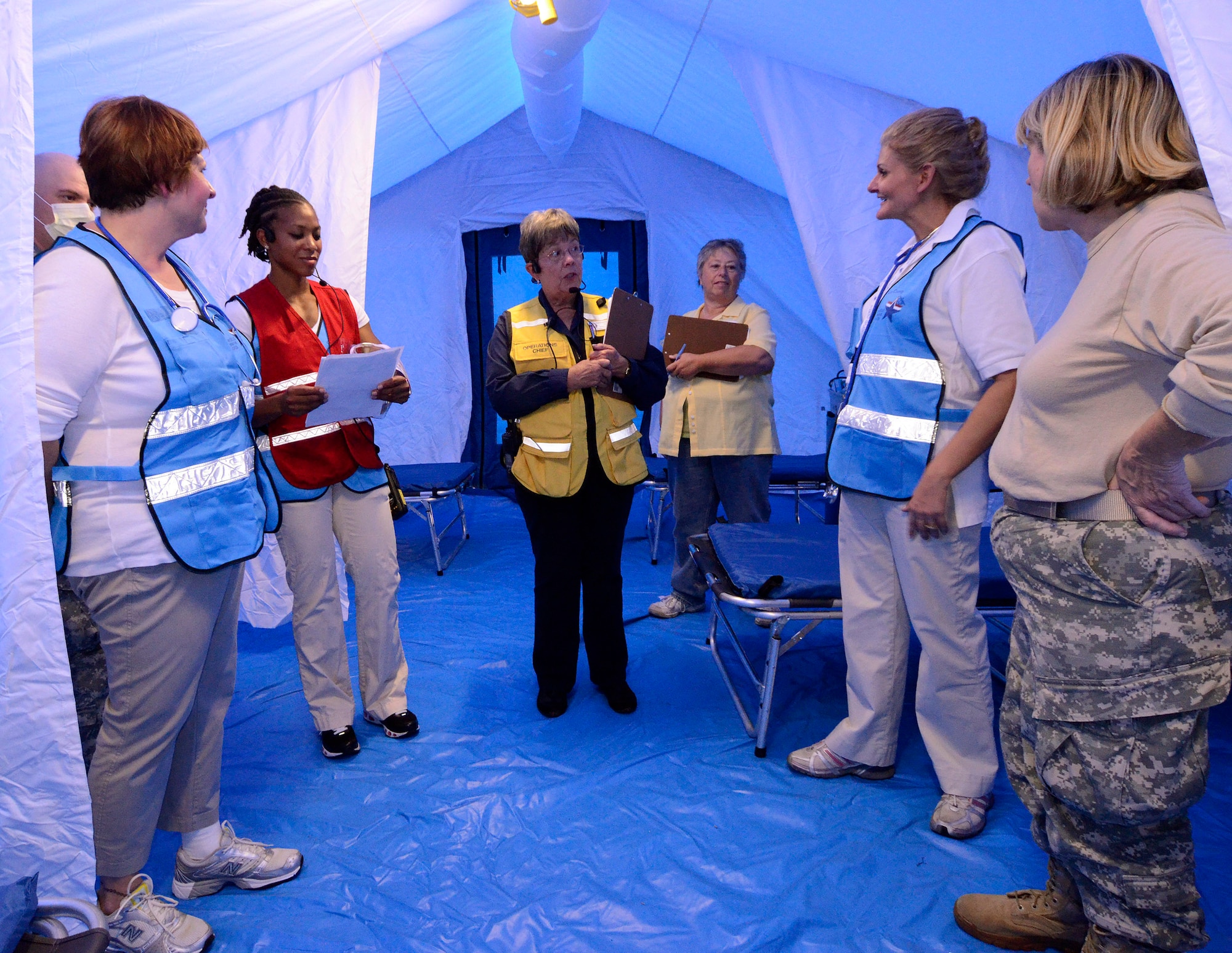 Pam Blackwell, director of emergency preparedness for Cobb & Douglas Public Health Department (center), discusses some early observations with members of the Georgia State Defense Force at the end of a mass casualty exercise at Dobbins Air Reserve Base, Oct. 8. The Cobb Douglas Public Health office ran the mass casualty exercise using their Mobile Surge Unit to help prepare local civilian medical personnel for a mass casualty event.   (U.S. Air Force photo/ Brad Fallin)