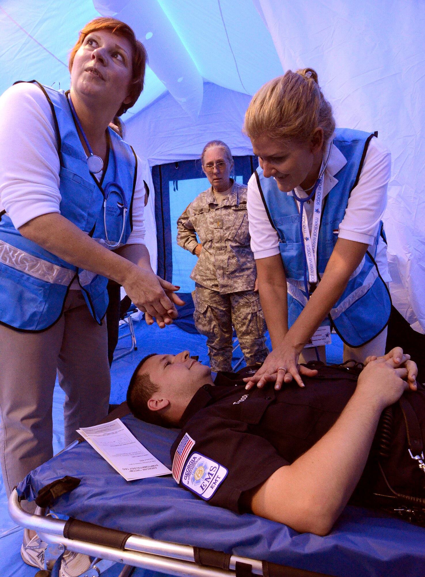 Georgia State Defense Force personnel perform simulated chest compressions on a role playing patient during a mass casualty exercise at Dobbins Air Reserve Base, Oct. 8. The Cobb & Douglas Public Health office ran the mass casualty exercise using their Mobile Surge Unit to help prepare local civilian medical personnel for a mass casualty event.   (U.S. Air Force photo/ Brad Fallin)