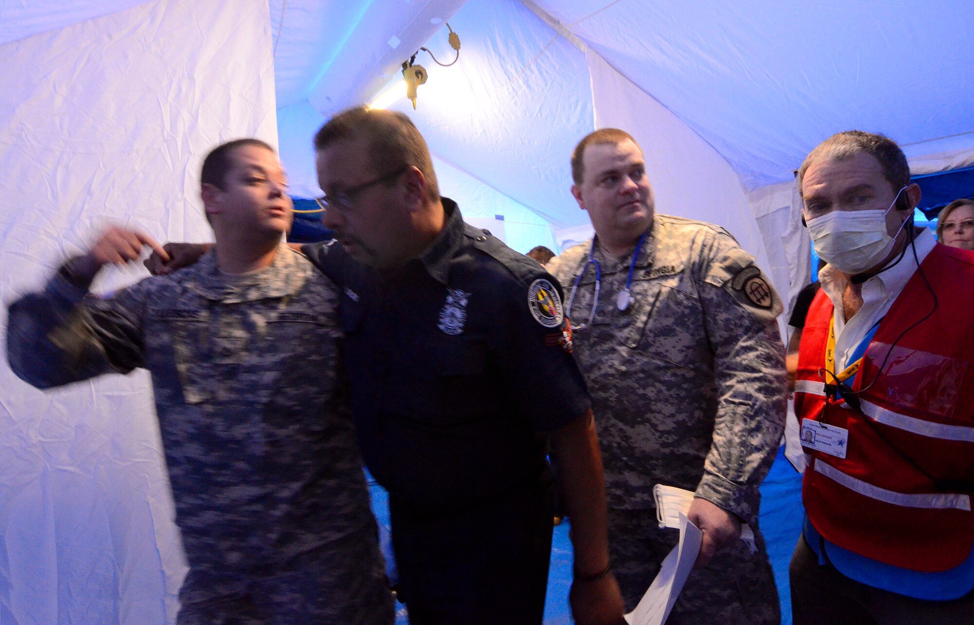 Georgia State Defense Force personnel quickly move a role playing patient to a treatment area within a mobile mass care facility during an exercise at Dobbins Air Reserve Base, Oct. 8. The Cobb & Douglas Public Health office ran the mass casualty exercise using their Mobile Surge Unit to help prepare local civilian medical personnel for a mass casualty event.   (U.S. Air Force photo/ Brad Fallin)