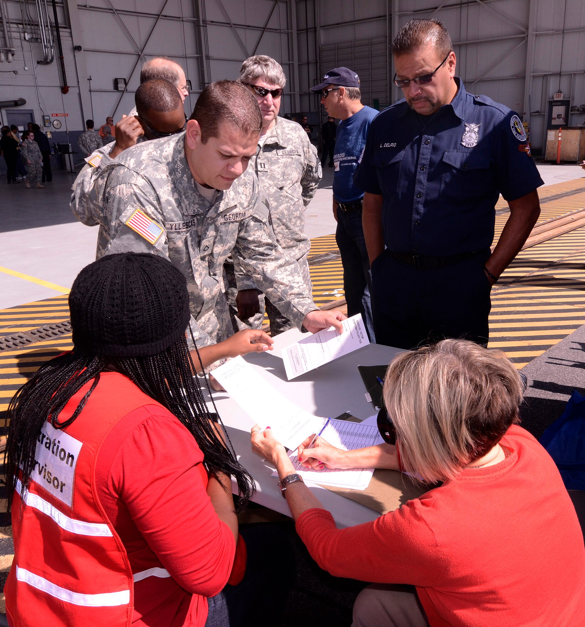 Members of the Georgia State Defense Force check in a walking wounded role playing patient during a mass casualty exercise at Dobbins Air Reserve Base, Oct. 8. The Cobb & Douglas Public Health office ran the mass casualty exercise using their Mobile Surge Unit to help prepare local civilian medical personnel for a mass casualty event.   (U.S. Air Force photo/ Brad Fallin)