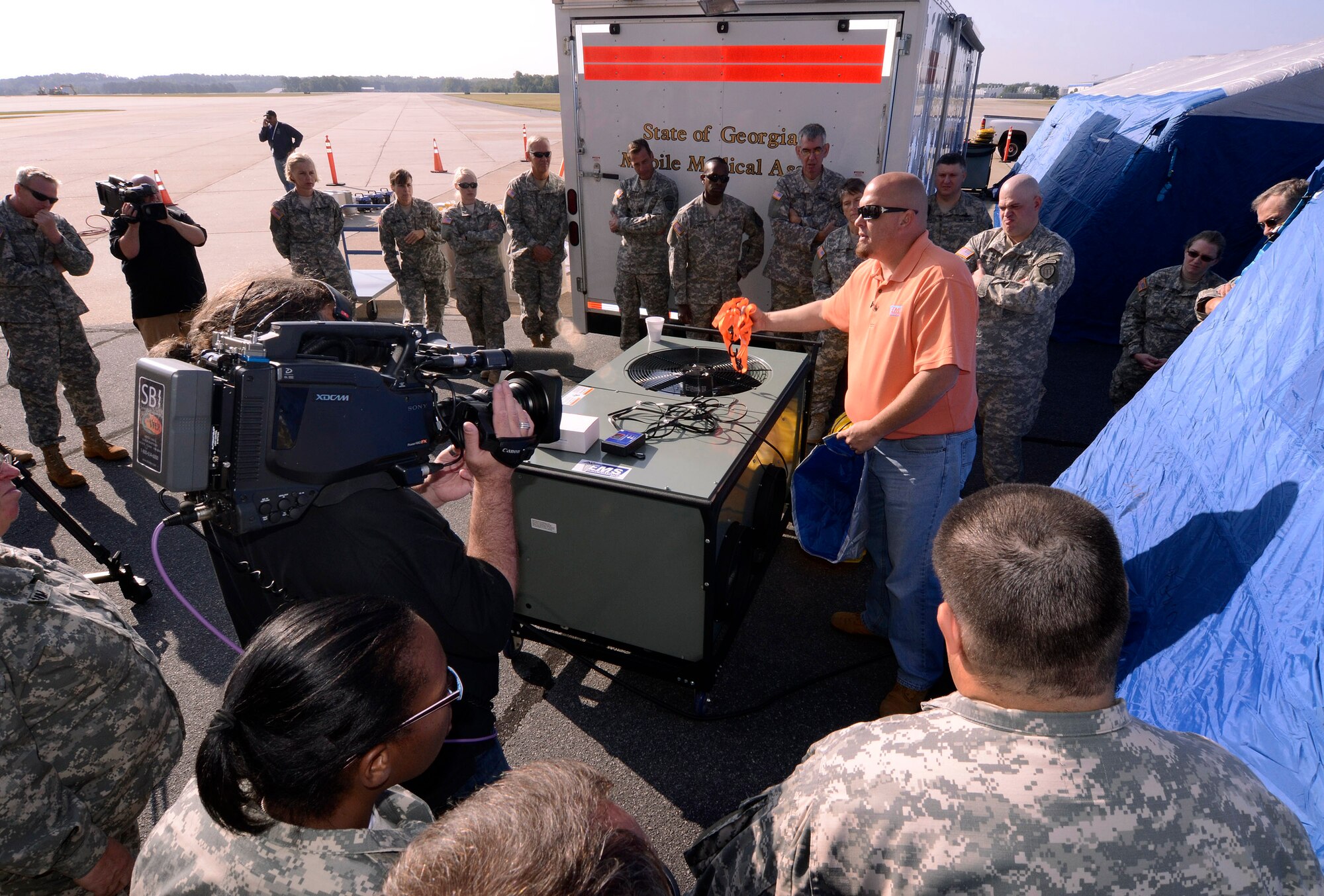 Skip Stephenson, sales representative for EMS Innovations Inc., briefs members of the Georgia State Defense Force on how to set up the air conditioning unit for his company's 50 bed mobile surge unit for a mass casualty exercise at Dobbins Air Reserve Base, Oct. 8. The Cobb & Douglas Public Health office ran the mass casualty exercise using their Mobile Surge Unit to help prepare local civilian medical personnel for a mass casualty event.   (U.S. Air Force photo/ Brad Fallin)