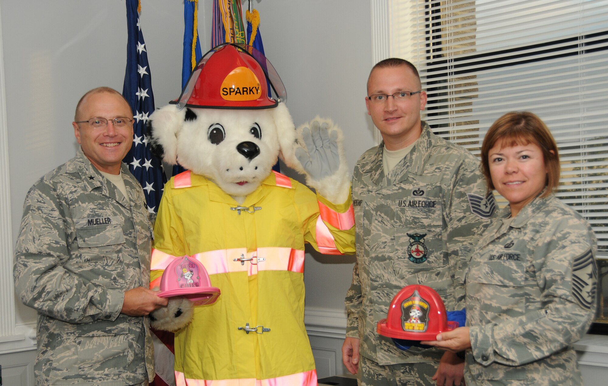 Left, Brig. Gen. Andrew Mueller, 81st Training Wing commander, Keesler Air Force Base, Miss.; Sparky the Dog; Tech. Sgt. Daniel Blankenship, Keelser fire inspector; and Chief Master Sgt. Angelica Johnson, 81st TRW command chief, pose for a photo opportunity Oct. 11, inside Mueller's office, as an introduction to Fire Prevention Week which will run Oct. 11-15, 2011.  (U.S. Air Force photo by Kemberly Groue)