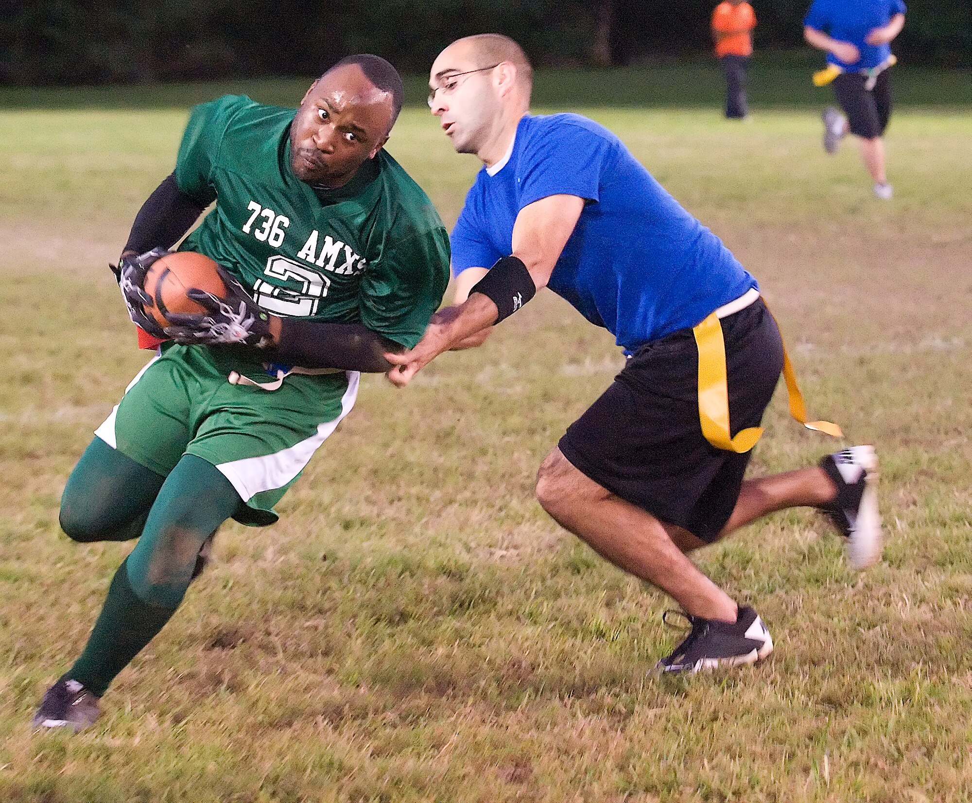 Elrico Edwards (left) runs to evade David Arceneaux Oct. 6, 2011, at Dover Air Force Base, Del. The 736th Aircraft Maintenance Squadron defeated the 436th Communications Squadron 42-21. (U.S. Air Force photo by Airman 1st Class Samuel Taylor) 