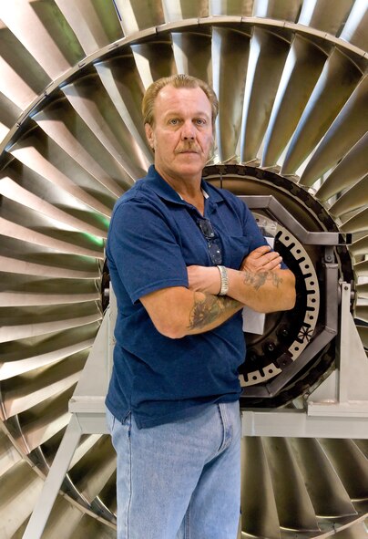 Larry Phillips, jet-engine-module-repair shop supervisor with the 436th Maintenance Squadron, stands in front of a TF-39 fan blade Oct. 6, 2011, at Dover Air Force Base, Del. Phillips has won more than $40,000 for his Innovative Development through Employee Awareness submissions, which have improved the repair process for the TF-39 engine. (U.S. Air Force photo by Roland Balik)