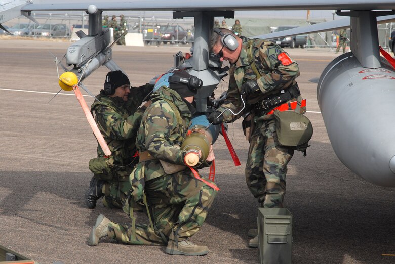 Members of the 140th Wing load munitions onto the wing of an F-16 prior to take off. From the Airmen on the ground to the pilots in the sky, each member of the 140th Wing plays a key role in the success of the mission. (U.S. Air Force Photo)