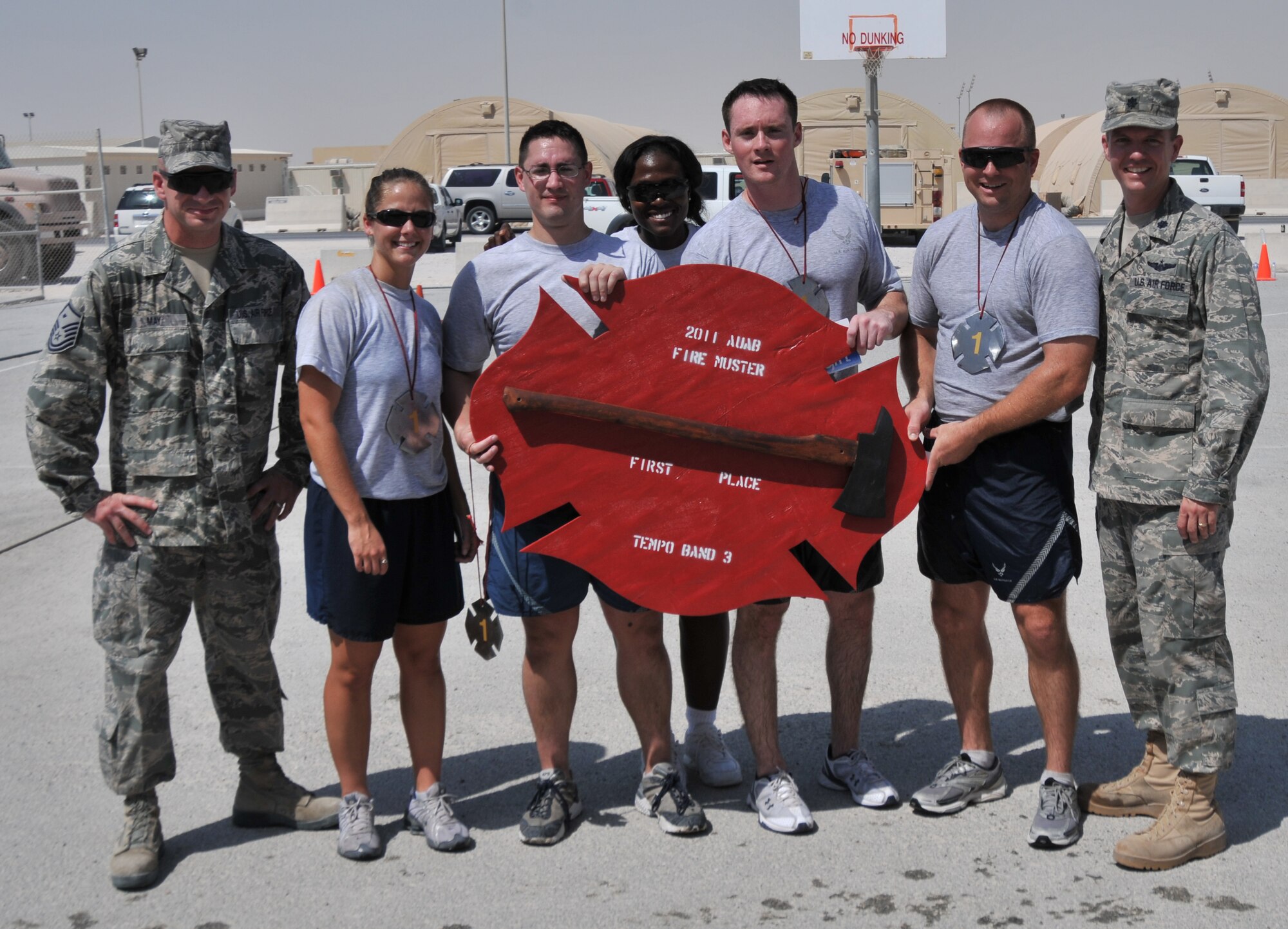 Team Arabian Knights, made up of Airmen from the 379th Expeditionary Operations Support Squadron, pose with their first place medallions and trophy after winning the Fire Muster competition, Oct. 8, 2011, at an undisclosed location in Southwest Asia. The Knights were one of 20 teams to compete in events made to resemble activities firefighters perform on a daily basis. (U.S. Air Force photo/Senior Airman Eric Summers Jr.) 