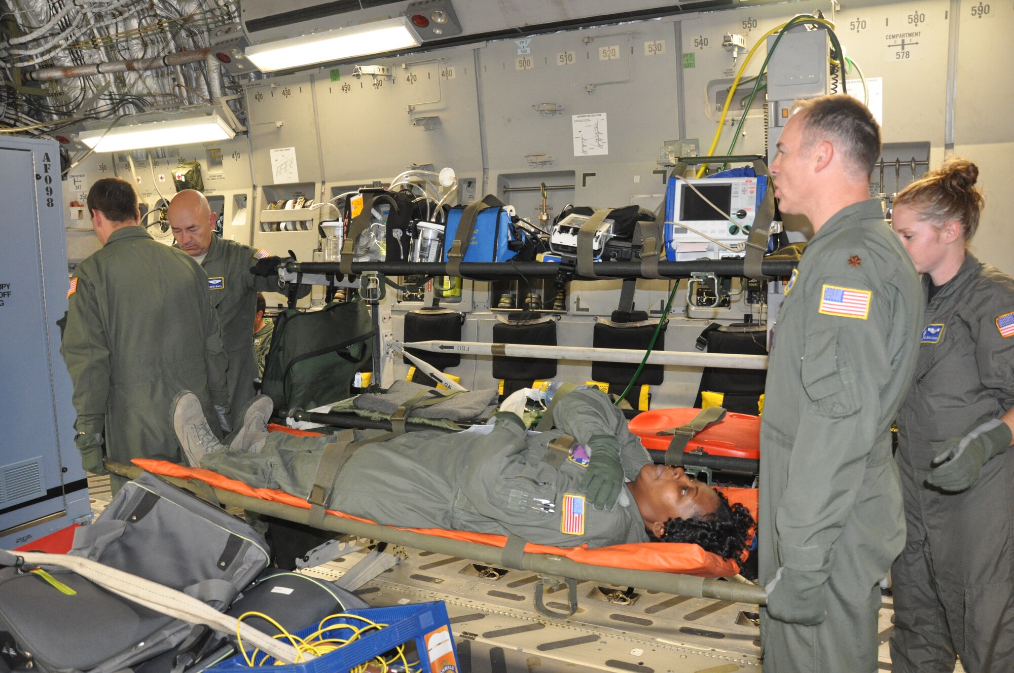Lt. Col. David Ball (left facing forward), a flight nurse with the 315th Aeromedical Evacuation Squadron, Joint Base Charleston, supervises a group of Airmen as they load a mock patient on litters during a recent Aeromedical Evacuation training flight.  (U.S. Air Force photo/2 Lt. Jeff Kelly)