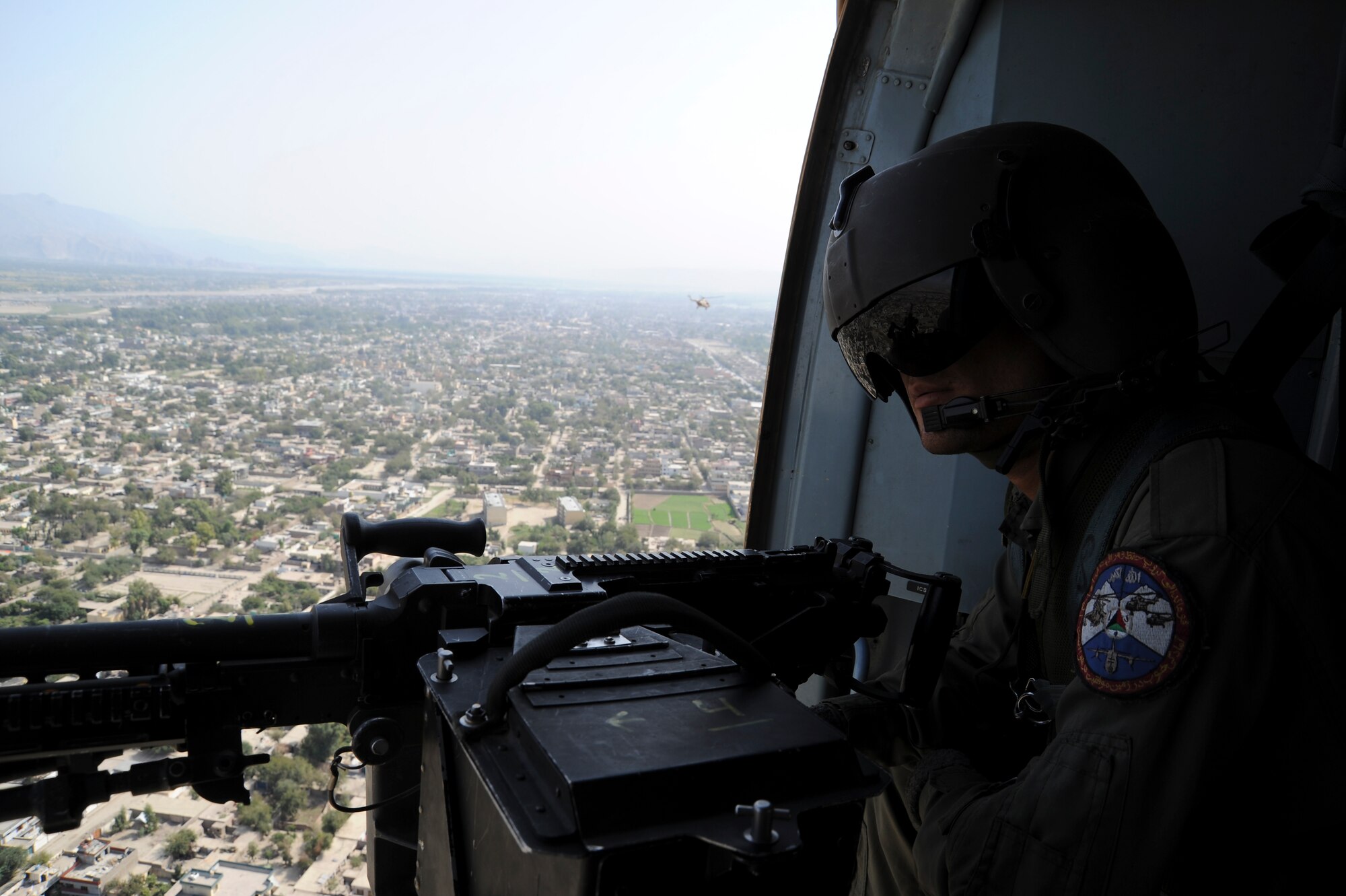Afghan Air Force airman Abdul Gahar, a crew chief, mans his M240 machine gun as he looks out over the Afghan country side while flying in an AAF Mi-17 helicopter, somewhere over Afghanistan. October 08, 2011. The helicopter was flying from Kabul to Jalalabad. (U.S. Air Force photo by Staff Sgt. Matthew Smith) 