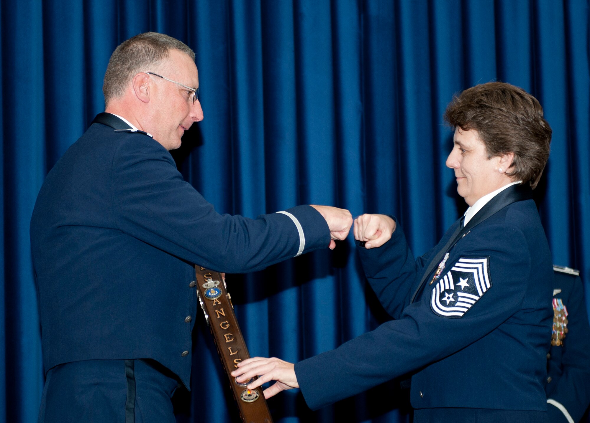 Col. Jay Cloutier, 39th Medical Group commander, left, receives the spirit award from Chief Master Sgt. Nancy Judge, 39th Air Base Wing command chief, during the Class 12-1 Incirlik Airman Leadership School graduation Oct. 7, 2011, at Incirlik Air Base, Turkey. The spirit stick is awarded to the group that displays the most spirit or enthusiasm for their Airmen during the ALS graduation. (U.S. Air Force photo by Senior Airman Anthony Sanchelli/Released) 