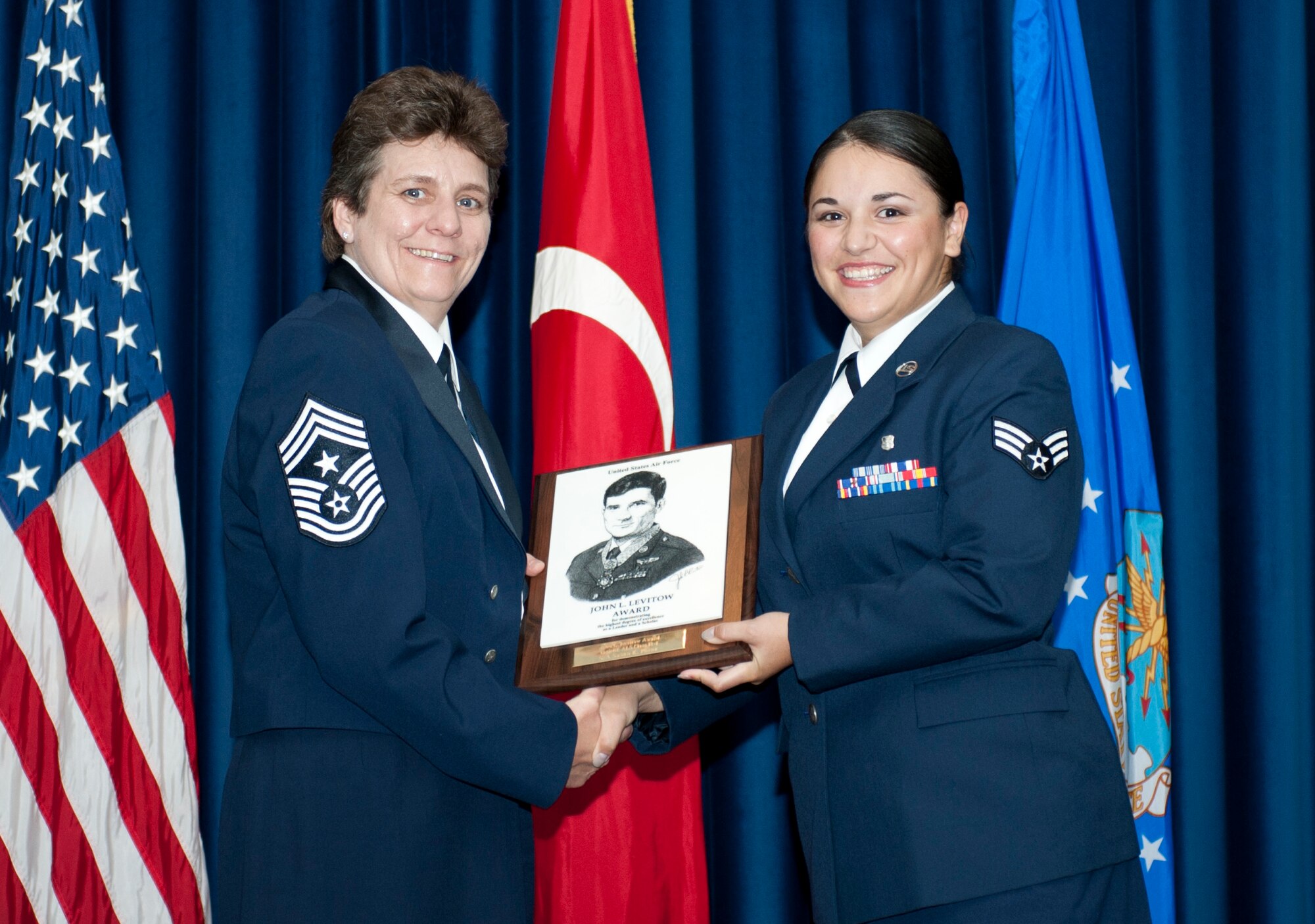 Senior Airman Susan Perez, 39th Medical Operations Squadron, right, receives the John L. Levitow award from Chief Master Sgt. Nancy Judge, 39th Air Base Wing command chief, during the Class 12-1 Incirlik Airman Leadership School graduation Oct. 7, 2011, at Incirlik Air Base, Turkey. The Levitow Award is the highest achievement for enlisted Airmen enrolled in U.S. Air Force professional military education. There are four levels of PME: ALS, NCO academy, Air Force Senior NCO Academy and Chief Master Sergeant Leadership Course. (U.S. Air Force photo by Senior Airman Anthony Sanchelli/Released) 
