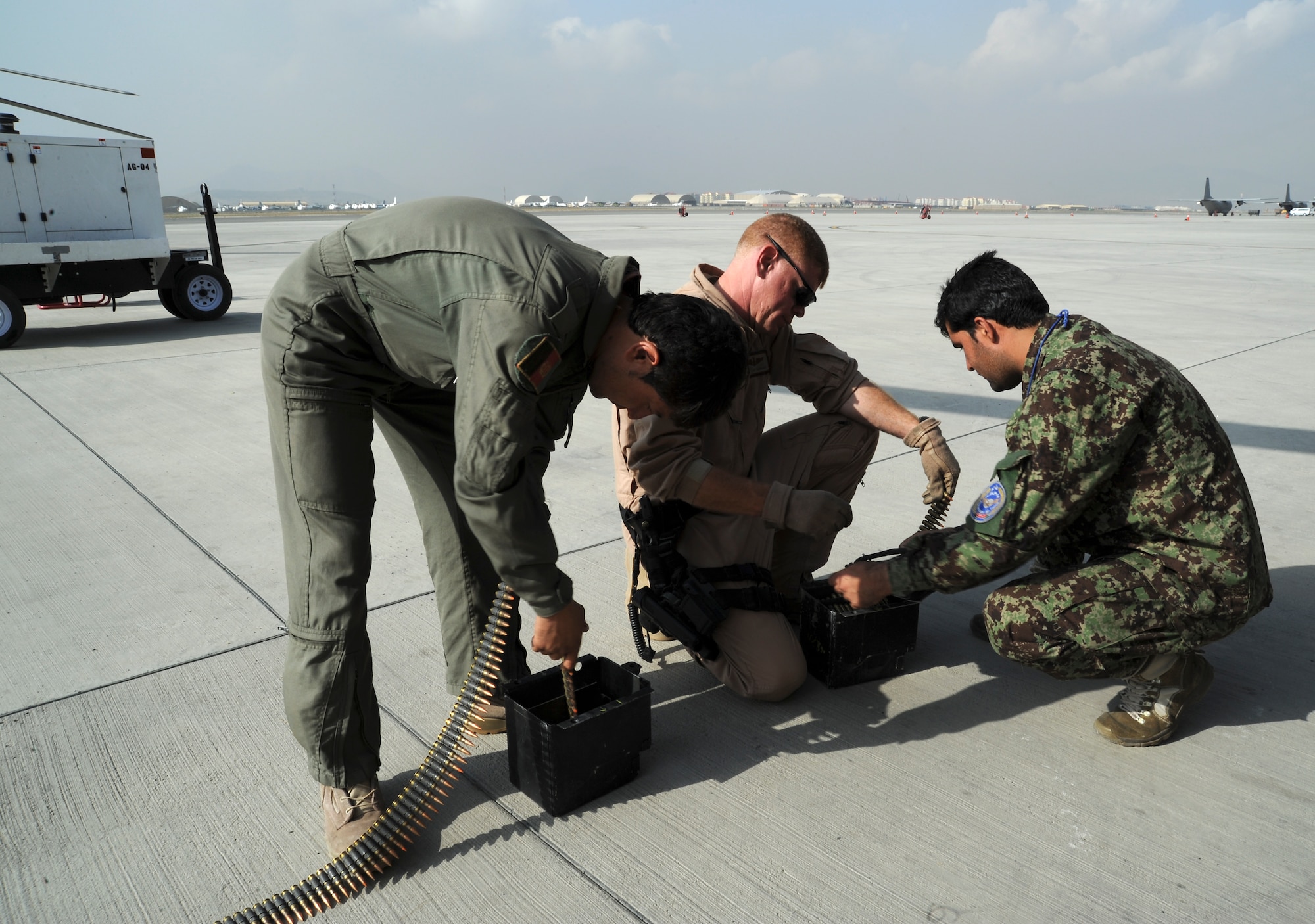 U.S. Air Force Master Sgt. Jay Simmons, a flight engineer with the 438th Air Expeditionary Advisory Squadron, loads up a canister with 7.62mm ammo in preparation for a flight aboard an Afghan Air Force Mi-17 helicopter, Kabul International Airport, Kabul, Afghanistan. October 8, 2011. The helicopter was going on a flying mission somewhere in Afghanistan. (U.S. Air Force photo by Staff Sgt. Matthew Smith)  
