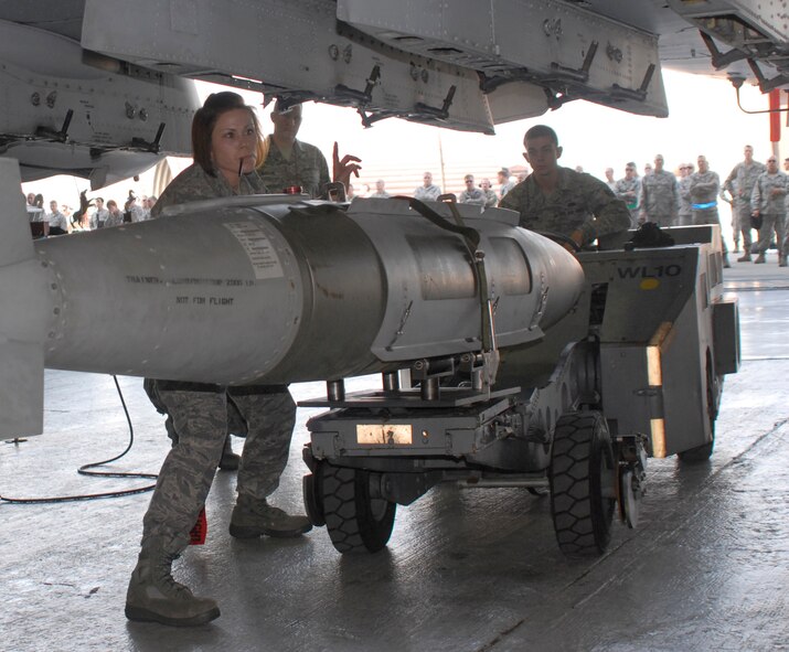 Staff Sgt. Malinda Lyons (left), 25th Aircraft Maintenance Unit weapons loader, signals instructions to Airman 1st Class Charles Clayton while loading a GBU-31 bomb on an A-10 during the 3rd Quarter Load Crew Competition Oct. 4. Crew 3 from the 25th AMU won the competition. (U.S. Air Force photo/Tech. Sgt. Eric Petosky)