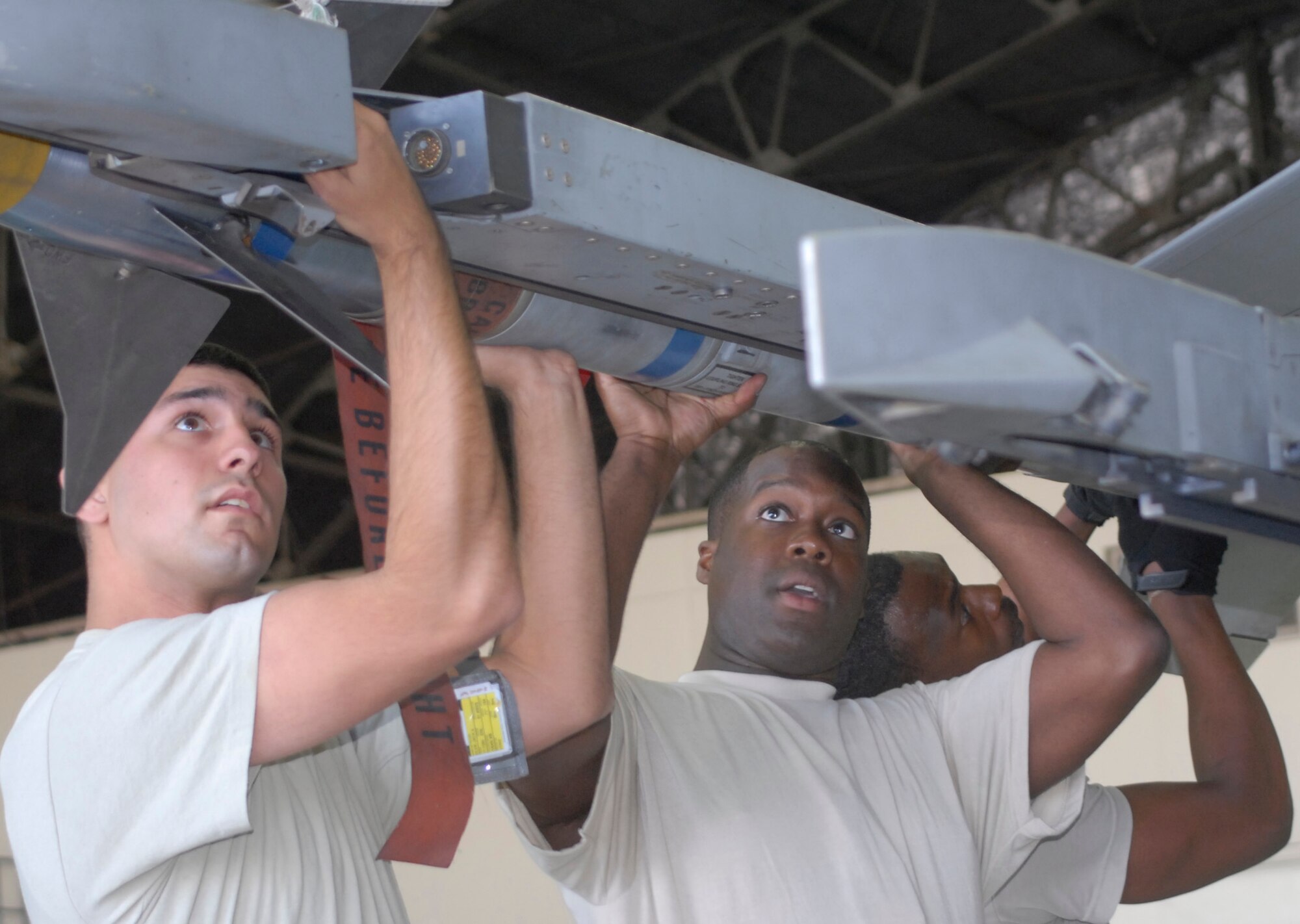 (From left to right) Airman 1st Class Jack Eiler, Staff Sgt. Chris Fleming, and Staff Sgt. Terry White, 36th Aircraft Maintenance Unit weapons loaders, attach an AIM-9LR missile to an F-16 during the 3rd Quarter Load Crew Competition Oct. 4. Crew 3 from the 25th AMU won the competition. (U.S. Air Force photo/Tech. Sgt. Eric Petosky)