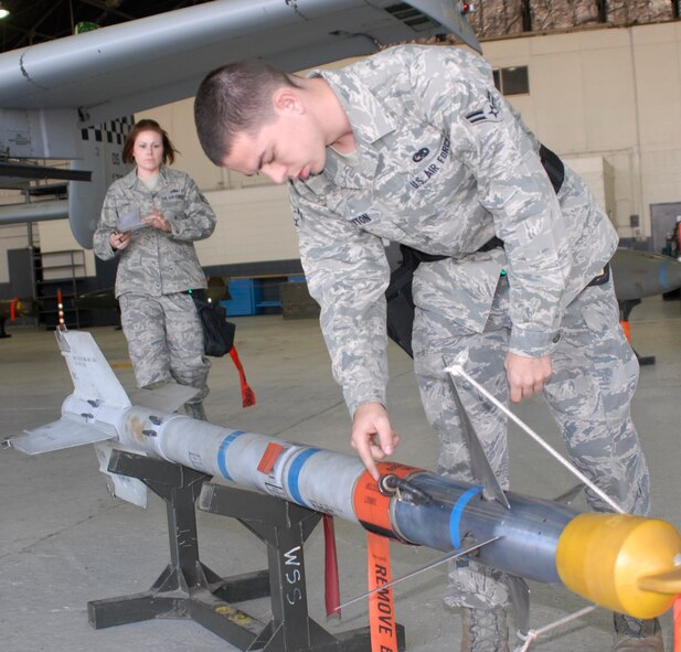 Airman 1st Class Charles Clayton (right), 25th Aircraft Maintenance Unit weapons loader, inspects an AIM-9LM missile under the watchful eye of Staff Sgt. Malinda Lyons during the 3rd Quarter Load Crew Competition Oct. 4. Crew 3 from the 25th AMU won the competition. (U.S. Air Force photo/Tech. Sgt. Eric Petosky)