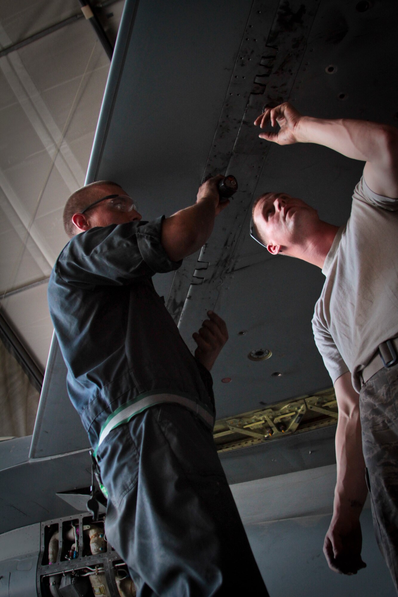 Airmen 1st Class Michael Jordan and Adam Sexton, 455th Expeditionary Aircraft Maintenance Squadron crew chiefs, secure wing panels on an F-16C Fighting Falcon Oct. 4, 2011.  Jordan, from Temecula, Calif., and Sexton, from Cincinnati, are both deployed from Aviano Air Base, Italy.  (U.S. Air Force Photo/Tech. Sgt. Matt Hecht)