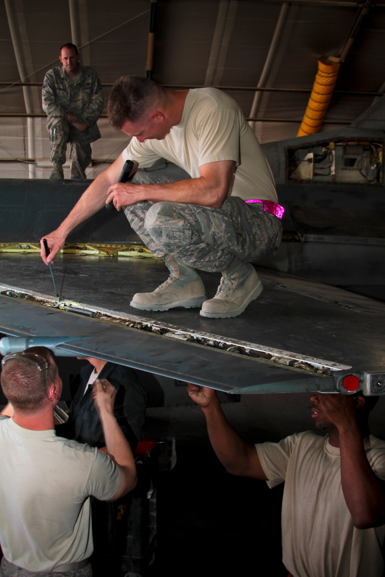 Tech. Sgt. Daniel Baker, 455th Expeditionary Aircraft Maintenance Squadron Quality Assurance, inspects the wing of an F-16C Fighting Falcon, while Tech. Sgt. Matt Thornburg, F-16 Phase Dock Noncommissioned Officer in Charge, observes Oct. 4, 2011.  Baker, who hails from Skidmore, Texas, and Thornburg from Bridgeman, Mich., are both deployed from Aviano Air Base, Italy.  (U.S. Air Force Photo/Tech. Sgt. Matt Hecht)