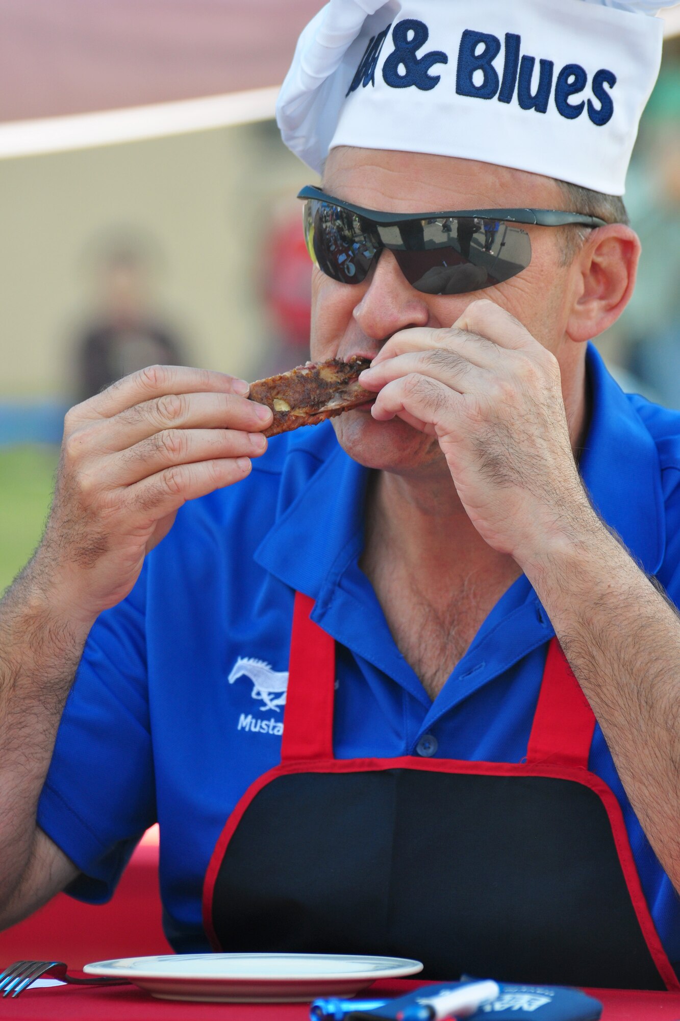 Col. Mark DeLong, 51st Fighter Wing Vice Commander and taste-test judge, tries a rib Oct. 9, 2011, during the 10th Annual “BBQ & Blues” event hosted by the 51st Force Support Squadron at the parking lot near the Officers Club. This day of free food and fun was filled with barbecued ribs and the sounds of music pounding away at the eardrums. Eighteen groups started their day at about 7 a.m. to compete to be crowned the team with the best ribs on base. (U.S. Air Force photo/Tech. Sgt. Chad Thompson)