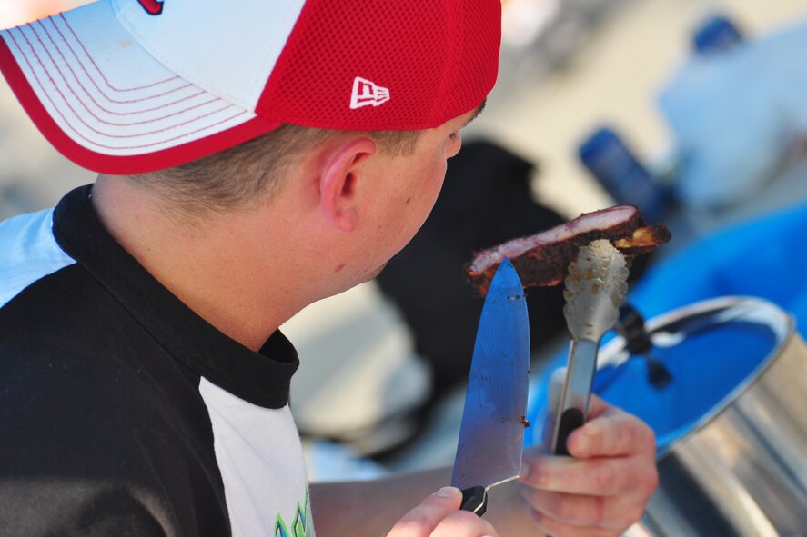 Staff Sgt. Doran Pribilski, 694th Intelligence Surveillance and Reconnaissance Squadron, finishes preparing his batch of ribs Oct. 9, 2011, during the 10th Annual “BBQ & Blues” event hosted by the 51st Force Support Squadron at the parking lot near the Officers Club. This day of free food and fun was filled with barbecued ribs and the sounds of music pounding away at the eardrums. Eighteen groups started their day at about 7 a.m. to compete to be crowned the team with the best ribs on base. (U.S. Air Force photo/Tech. Sgt. Chad Thompson)