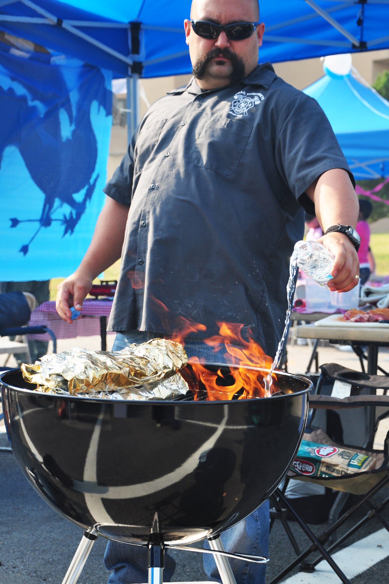 A competitor prepares his charcoal grill for a batch of ribs Oct. 9, 2011, during the 10th Annual “BBQ & Blues” event hosted by the 51st Force Support Squadron at the parking lot near the Officers Club. This day of free food and fun was filled with barbecued ribs and the sounds of music pounding away at the eardrums. Eighteen groups started their day at about 7 a.m. to compete to be crowned the team with the best ribs on base. (U.S. Air Force photo/Tech. Sgt. Chad Thompson)
