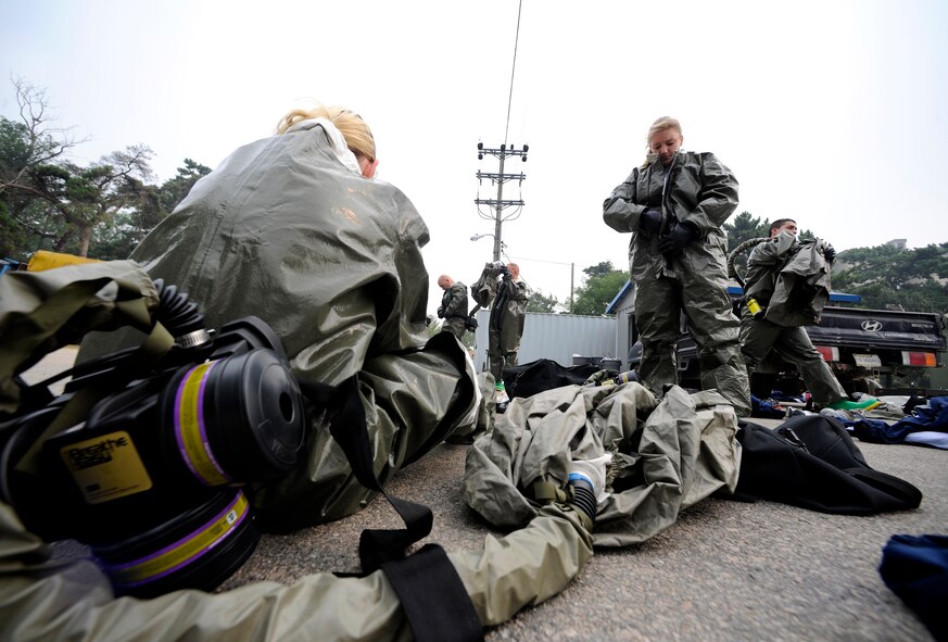 Medics from the 8th Medical Group's In-Place Patient Decontamination Team don their Disposable Toxic Agent Protective (DTAP) suits in preparation to receive contaminated patients in a simulated contaminated environment exercise at Kunsan Air Base, Republic of Korea, Oct. 6, 2011. The team spent two days, Oct. 5 and 6, 2011, undergoing training and instruction on chemical agents and proper decontamination procedures. (U.S. Air Force photo by Staff Sgt. Rasheen A. Douglas/Released)