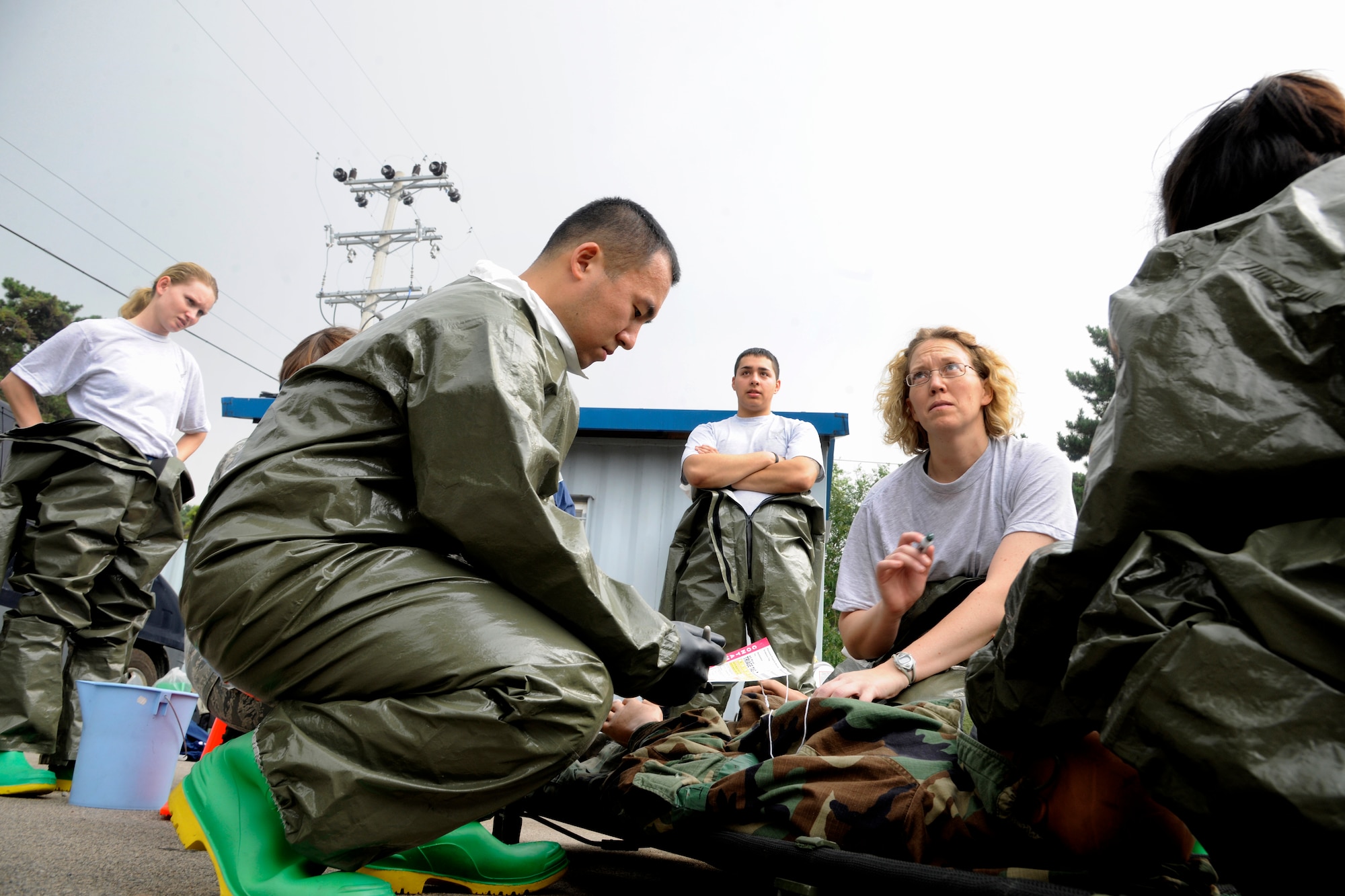 Medics from the 8th Medical Group's In-Place Patient Decontamination Team trains how to properly administer the appropriate amount of atropine to a contaminated patient in a simulated contaminated environment at Kunsan Air Base, Republic of Korea, Oct. 6, 2011. The team spent two days, Oct. 5 and 6, 2011, undergoing training and instruction on chemical agents and proper decontamination procedures. (U.S. Air Force photo by Staff Sgt. Rasheen A. Douglas/Released)