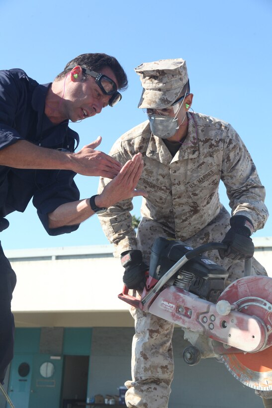 Andrew Birkhoff, a firefighter with the San Francisco Fire Department, gives Lance Cpl. Neil Unzuete, Combat Logistics Regiment 17, some last-minute advice about the circular saw, Oct. 7, 2011. Birkhoff, a San Francisco native, took time off to help train Unzuete and other Marines and sailors in urban search and rescue techniques. The training also helps Marines build relationships with local first responders.
