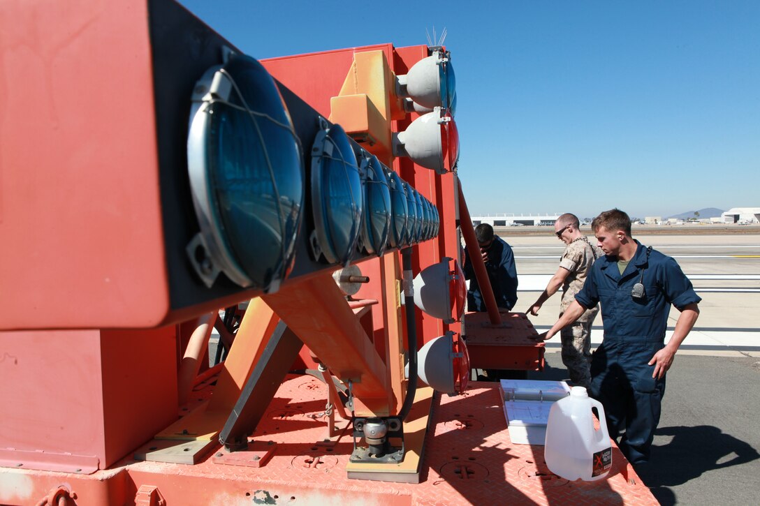 Aircraft recovery Marines use an Improved Fresnel Lens Optical Landing System to give glidepath information to pilots to help them land aboard Marine Corps Air Station Miramar, Calif. Before testing the IFLOLS, Marines must ensure it is level.
