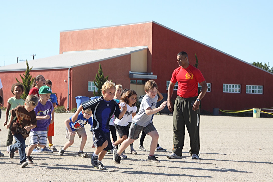 Staff Sgt. Owein M. Ramirez, a drill instructor with 1st Recruit Training Battalion, Alpha Company, tells students when to take off for a race during a visit to Holmes Elementary School as part of the Partnership in Education Program Tuesday. The PIE program consists of Marine volunteers visiting the school every other Tuesday to participate in physical educations classes in an effort to provide the students with positive role models.