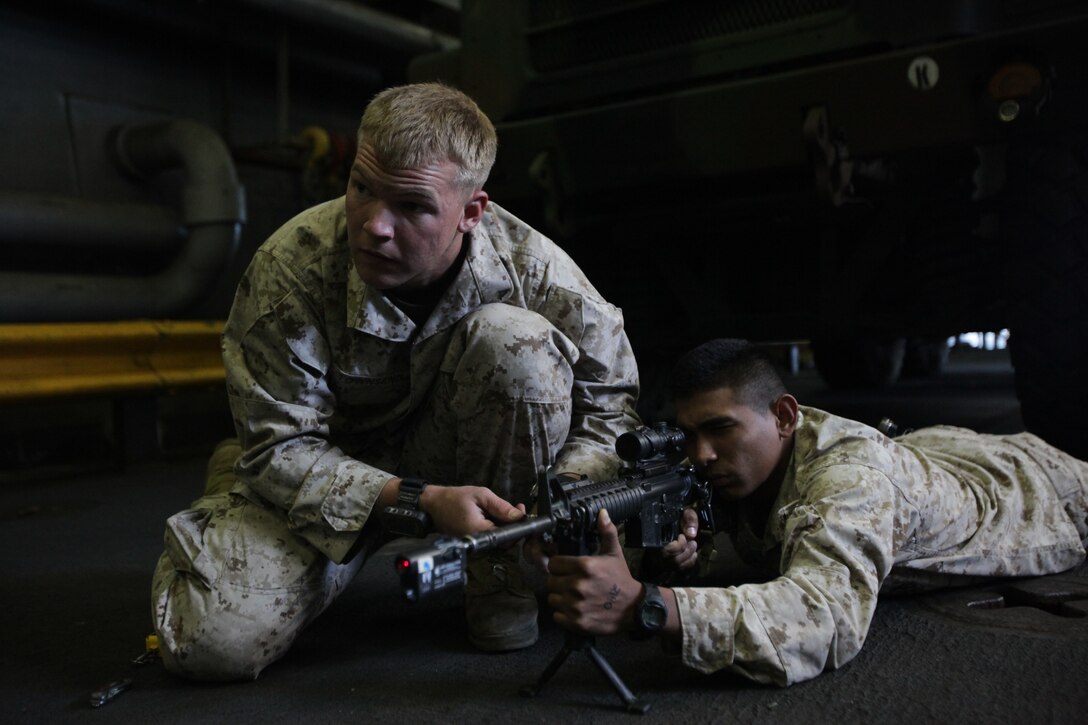 Lance Cpl. Troy R. Townsend, left, and Lance Cpl. Jorge J. Castro use a laser bore sight to adjust the aiming device on an M4 carbine here Oct. 11 before participating in a nighttime training raid with Company K. Company K is one of three rifle companies with Battalion Landing Team 3/1, the ground-combat element for the 11th Marine Expeditionary Unit. The unit embarked USS Makin Island, USS New Orleans and USS Pearl Harbor Sept. 28 for a final exercise before deploying in November. Townsend, 21, an infantryman, hails from Kilgore, Texas. Castro, 20, a mortarman, hails from San Benito, Texas.