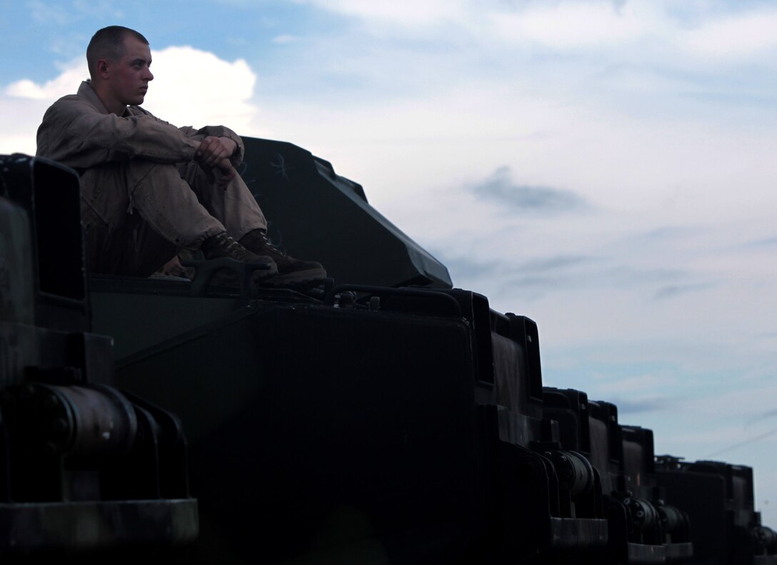 PFC Brandon Basket, amphibious vehicle mechanic, 2nd platoon, Company B, 2nd Assault Amphibian Battalion, 2nd Marine Division, sits atop an amphibious assault vehicle during the amphibious assault training conducted at Onslow Beach aboard Marine Corps Base Camp Lejeune, N.C., Oct. 12. Throughout the training, the AA Bn. was supported by the USS Ponce, an Austin-class amphibious transport dock named for Ponce, Puerto Rico, a city in the commonwealth of Puerto Rico.
