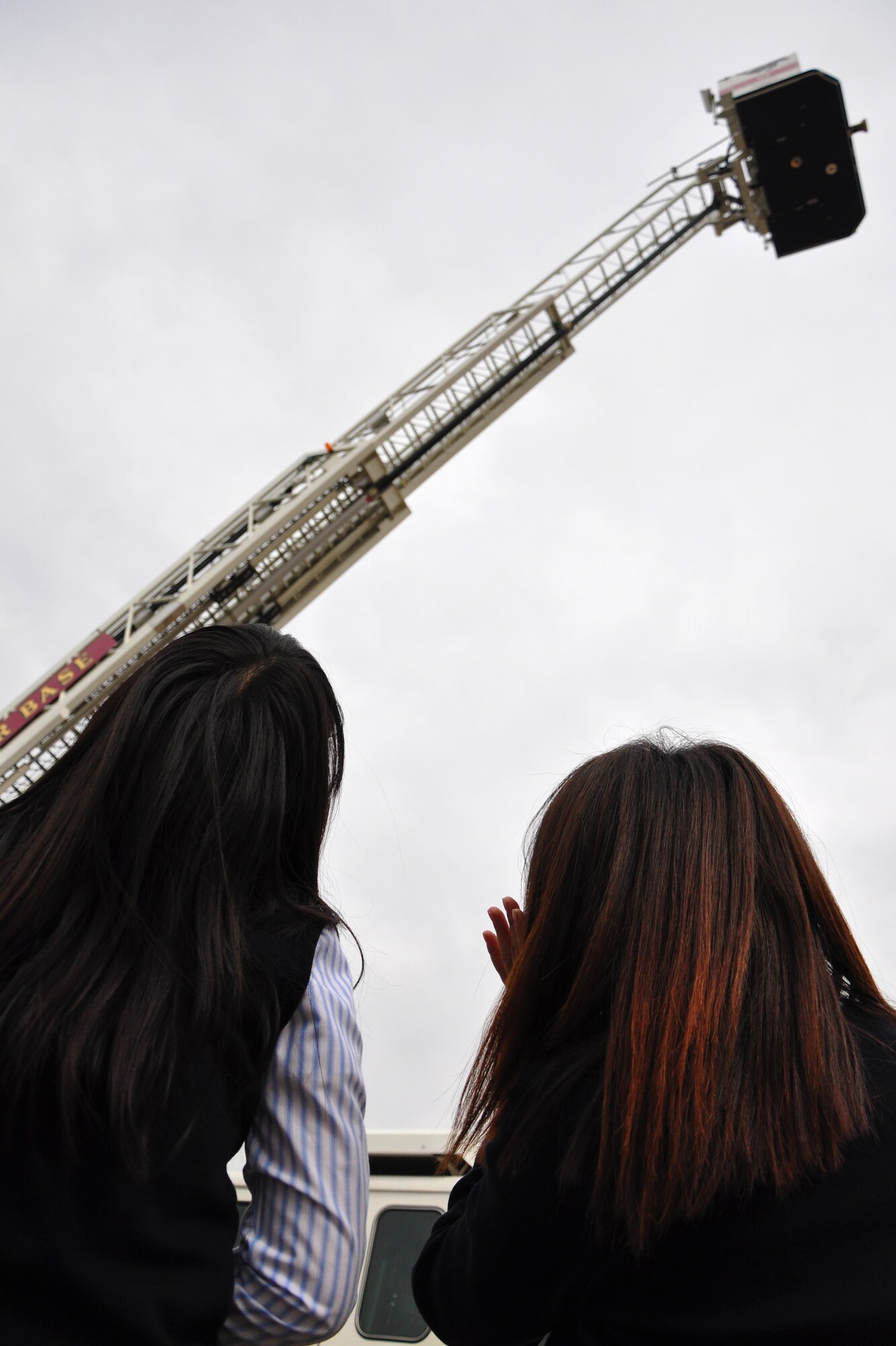 Two Korean middle school students watch as a ladder truck raises its ladder into the air during a visit to the Osan Fire Department Oct. 12, 2011. As a part of Fire Prevention Week, 21 students from a local Korean middle school toured the Osan Fire Department and got to see firsthand how a firefighter lives day to day. The students got to see several tools of the trade, learned about what a firefighter’s day is like and got a fire truck and ladder truck demonstration. Fire Prevention Week is the longest running public health and safety observance on record. (U.S. Air Force photo/Tech. Sgt. Chad Thompson)