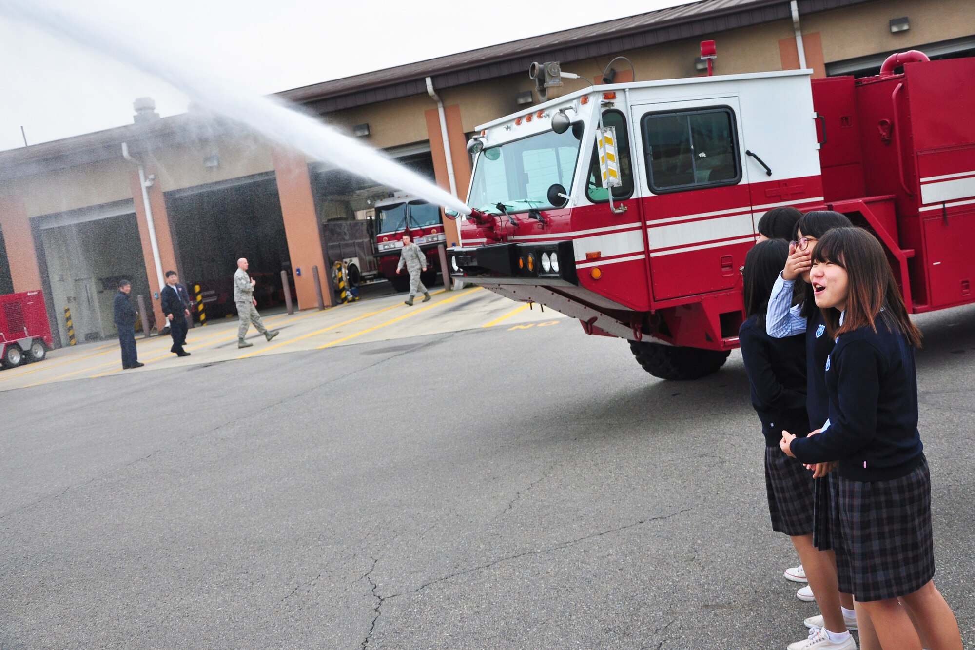 Students watch as a fire truck sprays water toward the flightline during a visit to the Osan Fire Department Oct. 12, 2011. As a part of Fire Prevention Week, 21 students from a local Korean middle school toured the Osan Fire Department and got to see firsthand how a firefighter lives day to day. The students got to see several tools of the trade, learned about what a firefighter’s day is like and got a fire truck and ladder truck demonstration. Fire Prevention Week is the longest running public health and safety observance on record. (U.S. Air Force photo/Tech. Sgt. Chad Thompson)