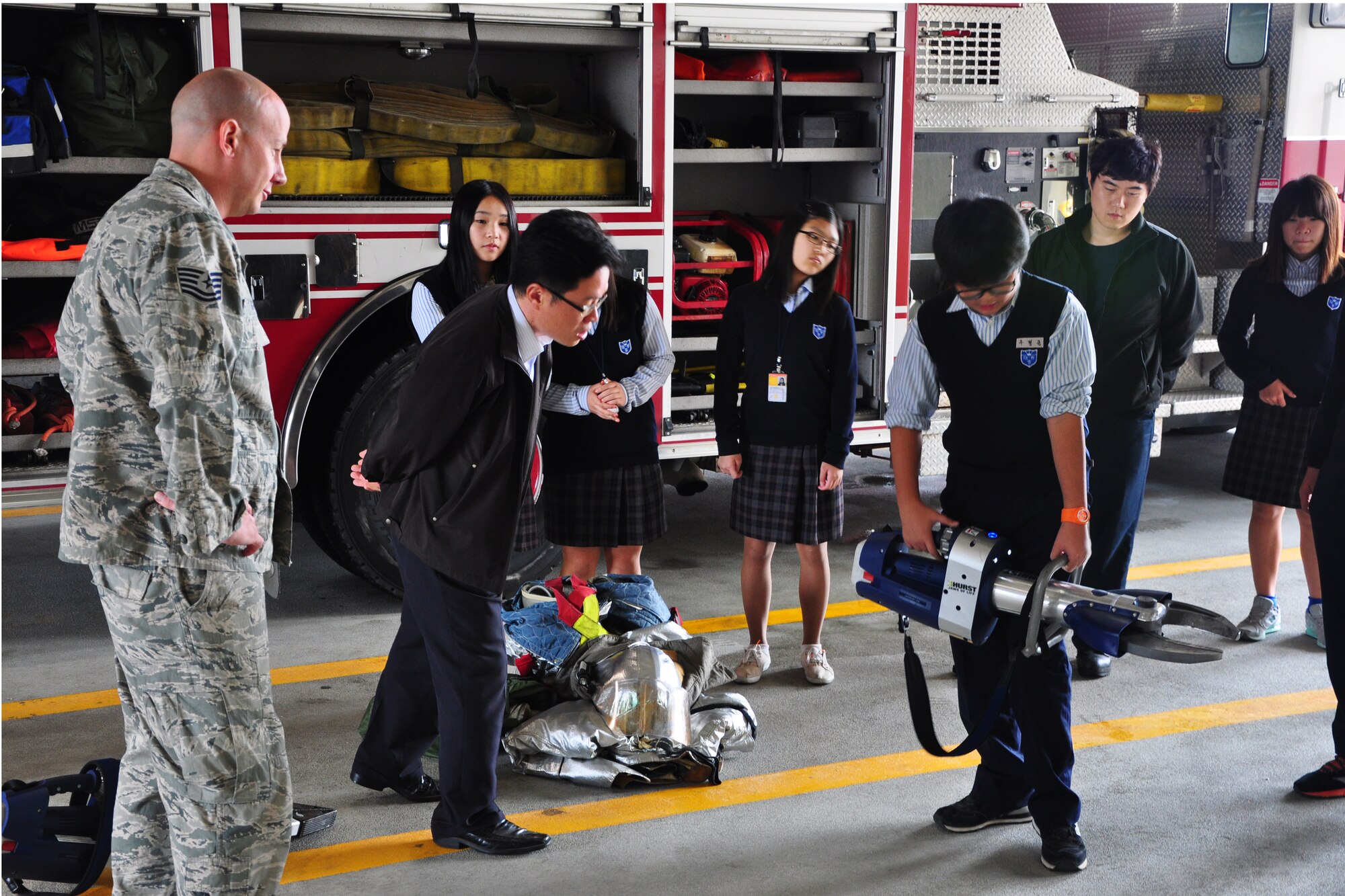 A Korean middle school student holds a “Jaws of life” electric tool during a visit to the Osan Fire Department Oct. 12, 2011. As a part of Fire Prevention Week, 21 students from a local Korean middle school toured the Osan Fire Department and got to see firsthand how a firefighter lives day to day. The students got to see several tools of the trade, learned about what a firefighter’s day is like and got a fire truck and ladder truck demonstration. Fire Prevention Week is the longest running public health and safety observance on record. (U.S. Air Force photo/Tech. Sgt. Chad Thompson)