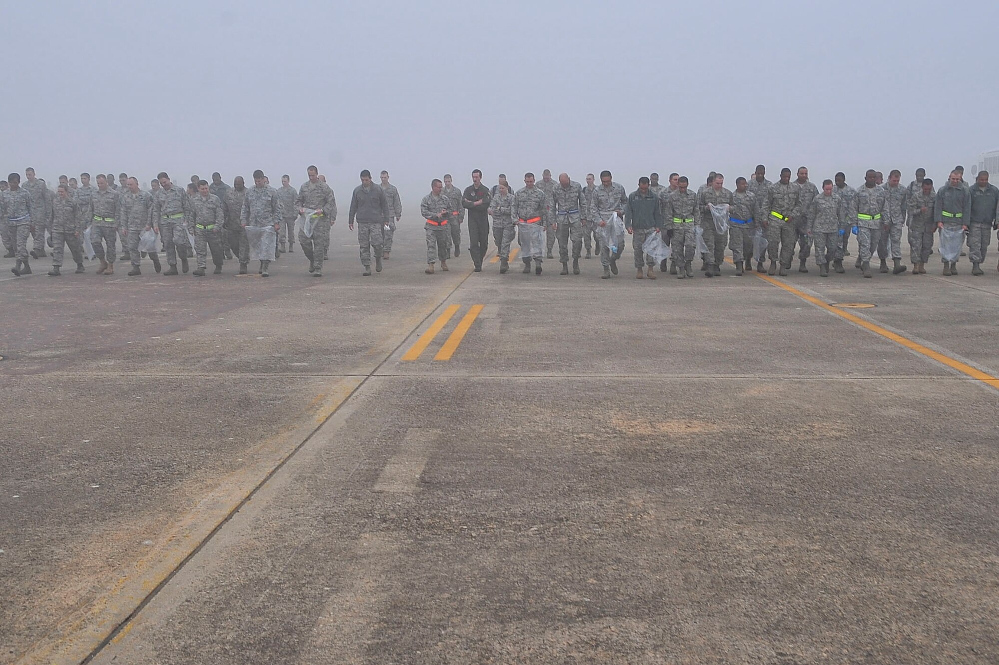 Airmen from the 51st Fighter Wing form a line and move forward searching for debris during the wing’s Foreign Object Debris walk on Oct. 11, 2011.The wing-wide FOD was conducted following construction on the Osan Air Base airfield. (U.S. Air Force photo/Senior Airman Adam Grant)     