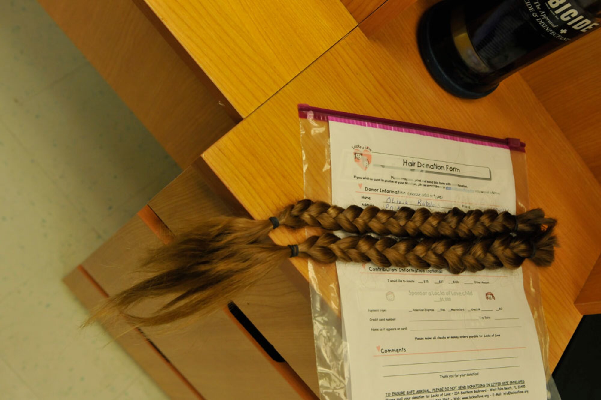 Rabelais’ certificate of hair donation and the braids. (U.S. Air Force photo/Steven White)